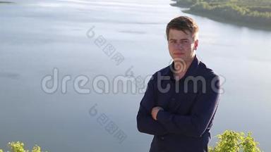 一幅年轻迷人的男子将头发固<strong>定</strong>在相机前的巨大河畔边<strong>缘</strong>的肖像。